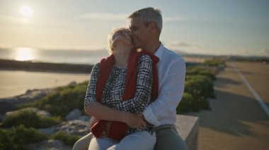 Yaşlı bir çift deniz kenarında romantik bir gün batımının tadını çıkarıyor, kahkahalarını ve sevgilerini paylaşıyorlar.