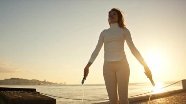 Lizbon 'da güneş doğarken atlama ipiyle atlama eğitimi alan sporcu kadın.