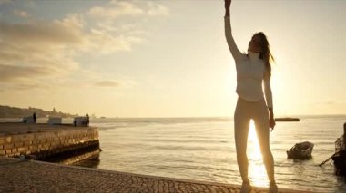 Gün batımında nehirde dans eden zarif bir kadın.