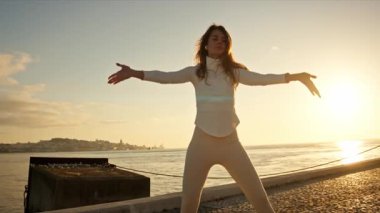 Tagus nehrinin orada, Lizbon 'da Tai Chi Chuan pratiği yapan genç bir kadın.