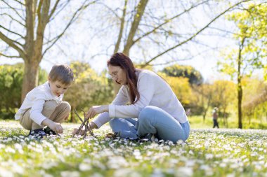 Anne ve oğlu güneşli bir bahar gününün tadını çıkarıyorlar. Papatya tarlasında dalları olan küçük bir çadır kuruyorlar.