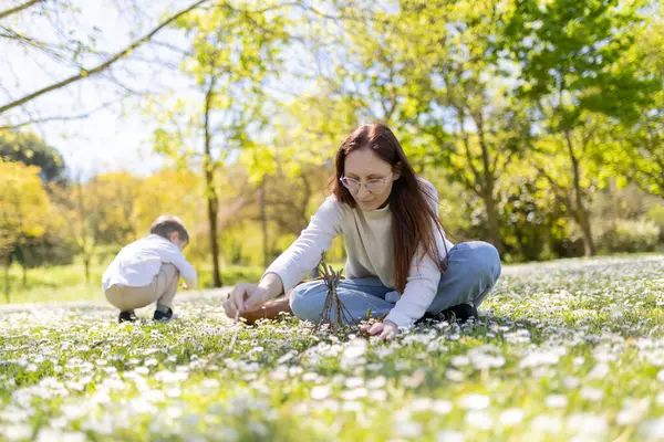 Anne ve oğlu güneşli bir bahar gününün tadını çıkarıyor papatya tarlasında küçük bir çadır kuruyorlar.