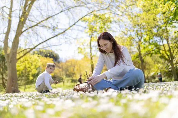 Anne ve oğlu güneşli bir bahar gününün tadını çıkarıyorlar. Papatya dolu bir tarlada dalları olan küçük bir kulübe yapıyorlar.