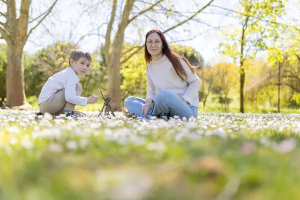 Anne ve oğul parkta bahar gününün tadını çıkarıyorlar. Çiçekli çayırlarda dalları olan küçük bir çadır kuruyorlar.