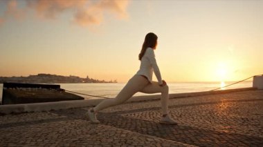 Nehrin kenarında savaşçı pozu veren kadın.