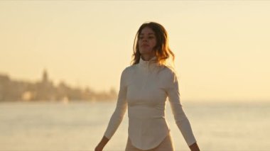 Güneş batarken deniz kenarında atlama ipiyle atlama eğitimi alan sporcu kadın.