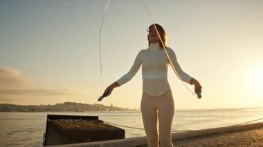 Nehir kenarında atlama ipiyle atlama eğitimi alan sporcu kadın.