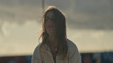 Enerjik kadın, bulutlu ve rüzgarlı bir günde çatıda atlama ipiyle egzersiz yapmaktan hoşlanır.