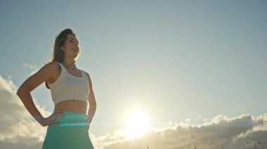 Batan güneşin altında poz veren genç atletik kadın