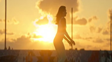 Kadınlar çatıda altın saat boyunca çömelme hareketleri yapıyorlar.