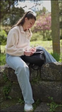 Gündelik öğrenci açık havada deftere bir şeyler yazıyor.