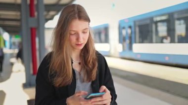 Ergen, ulaşımı bekliyor, sosyal medyayı araştırıyor.