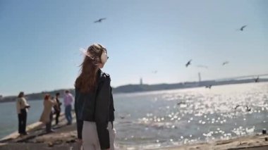 Portekiz, Lizbon 'da tagus nehri boyunca yürürken müziğin tadını çıkaran bir turist.