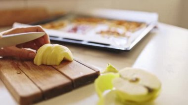 Kadınların ellerini dikkatlice bir tahta kesme tahtasıyla keserek lezzetli bir elmalı turtaya hazırlıyorlar.