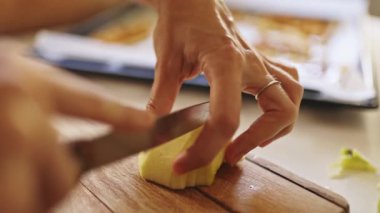 Ahşap kesme tahtasındaki elmaları dilimleyen kadın, elmalı turta malzemeleri hazırlayan kadın.