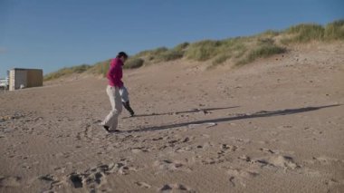 Anne ve oğlu güzel kumlu bir plajda birlikte güzel vakit geçiriyorlar.