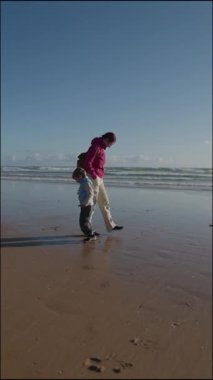 Baba ve oğul sahilde yürüyüş yapıyorlar.