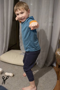 Gülümseyen çocuk evde dövüş sanatları çalışıyor.