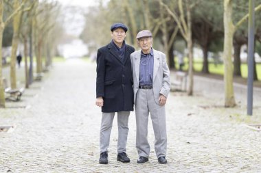 Soğuk bir kış gününde Asyalı aile parkta birlikte poz veriyor.