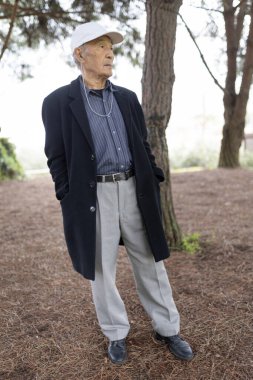 Son sınıf öğrencisi, parkta huzurlu bir anın tadını çıkarırken kulaklıkla müzik dinliyor.