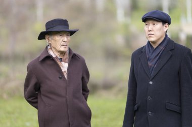 Parkta paltolu ve şapkalı iki kıdemli Asyalı adam muhtemelen manzarayı tartışıyor ya da eğleniyorlar.