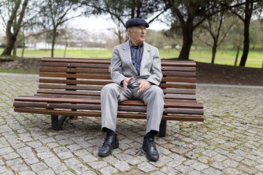 Kıdemli adam parkta huzurlu bir anın tadını çıkarıyor. Doğayla iç içe olan hayatı yansıtıyor.