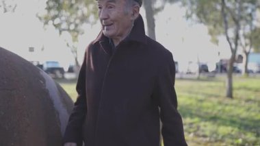 Kıdemli adam parkta gezintiye çıkıp müzik dinlemekten hoşlanıyor.