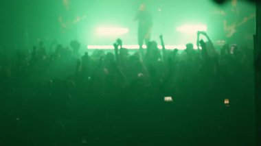 Hevesli hayranlar canlı müzikten, el kaldırmaktan ve telefonlarla video kaydetmekten zevk alıyorlar.