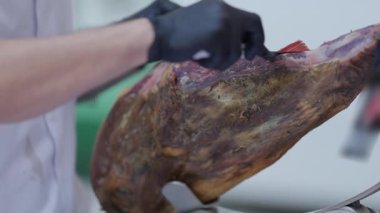 Profesyonel şef, jamon iberico 'nun bacağını ustalıkla kesiyor.