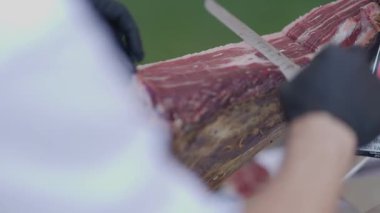 Şefin ellerini ustalıkla Jamon Iberico 'nun ince parçalarını dilimlerken yaklaş.