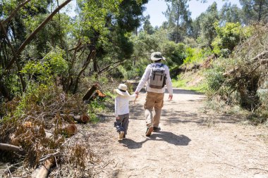 Baba ve oğul güzel bir yaz gününde sakin bir yürüyüş yaparak doğanın ortasında kalıcı anılar yaratıyorlar.