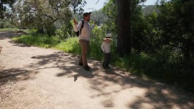 Baba ve oğul güneşli bir günde keyifli bir yürüyüş yapıyorlar.