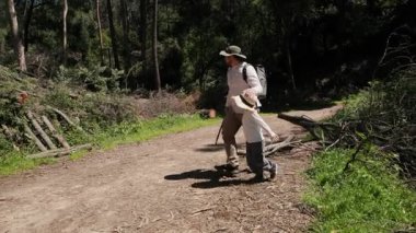 Baba ve oğul güneşli bir patikada keyifli bir yürüyüş yapıyorlar.