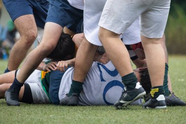 Rugby atletleri yoğun bir şekilde yarışıyor, sahada bir kargaşa yaratıyorlar.
