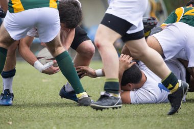 Ragbi oyuncuları bir ragbi maçı sırasında top için savaşıyor.