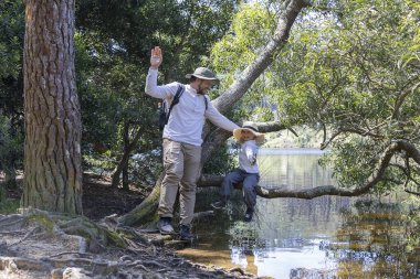 Baba ve oğul göl kenarında güneşli bir günün tadını çıkarıyor, doğayı keşfediyor ve birlikte anılar yaratıyorlar.