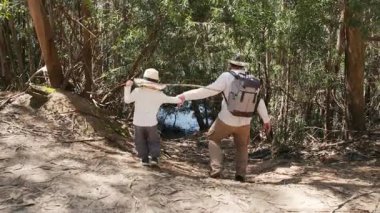 Baba ve oğul doğa yolunda sakin bir yürüyüşün tadını çıkarıyorlar.