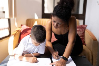 Anne, oğlunun okul masraflarına yardım ediyor, eğitim ve aile desteğini destekliyor.