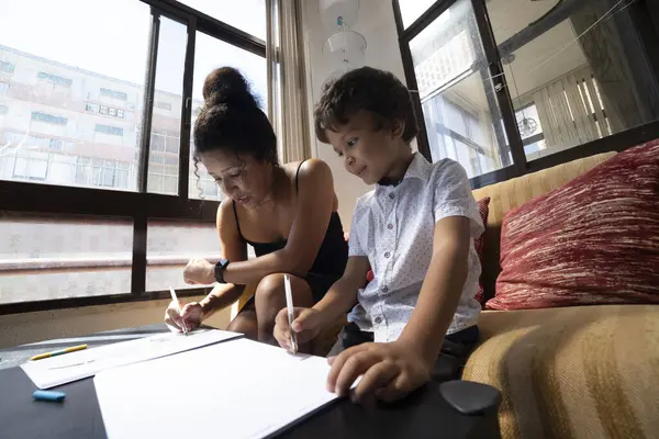 Anne ve oğul evde beraberce vakit geçiriyorlar.