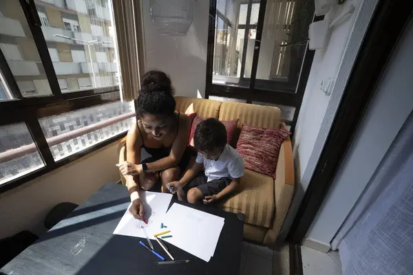 Güneşli bir günde anne ve oğlu birlikte çiziyorlar.