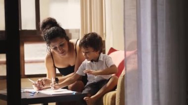 Anne oğluna çiziminde yardım ediyor, yürek ısıtan bir bağ ve yaratıcılık anı yaratıyor.