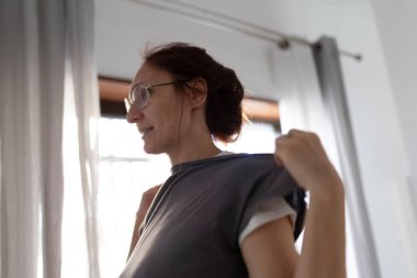 Anne bir bebek askısı takıyor bebeğini kucağına almaya hazırlanıyor