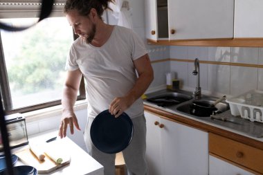 Şef malzemeleri topluyor, tabakları alıyor, yemek hazırlıyor.