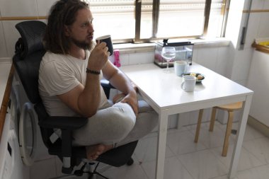 Freelancer mutfakta kahve molası veriyor, evden çalışıyor.