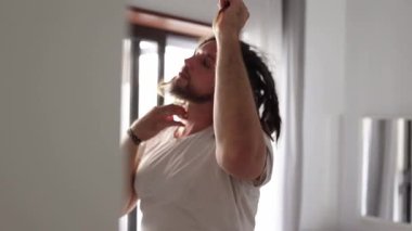 Adamın biri aynanın önünde rastalarını şekillendiriyor.