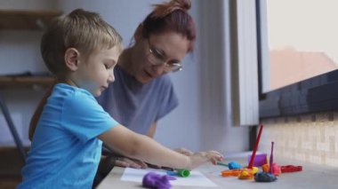 Anne ve oğlu kille yaratıcı oyun zamanının keyfini çıkarıyorlar.