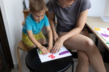 Anne ve oğul birlikte güzel vakit geçiriyorlar, kilden renkli sanat eserleri yapıyorlar.