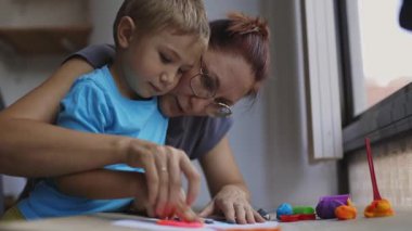 Anne ve oğlu kaliteli zaman geçiriyorlar, kilden renkli sanat eserleri yapıyorlar.