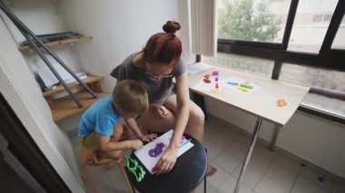Anne oğluna kil şekillendirmeyi öğretiyor. Birlikte eğlenceli bir öğrenme deneyimi yaşıyoruz.