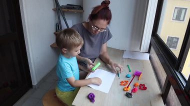 Anne ve çocuk, kille yaratıcı oyun zamanının keyfini çıkarıyorlar.